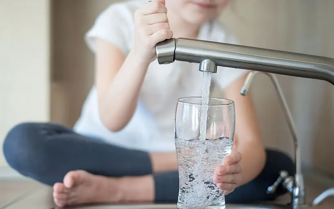 Little girl opens a water tap